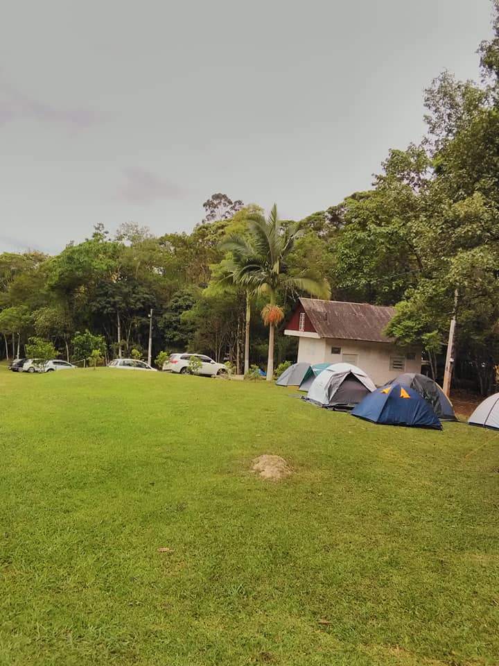 Barracas montadas no gramado, perto da casa e das árvores
